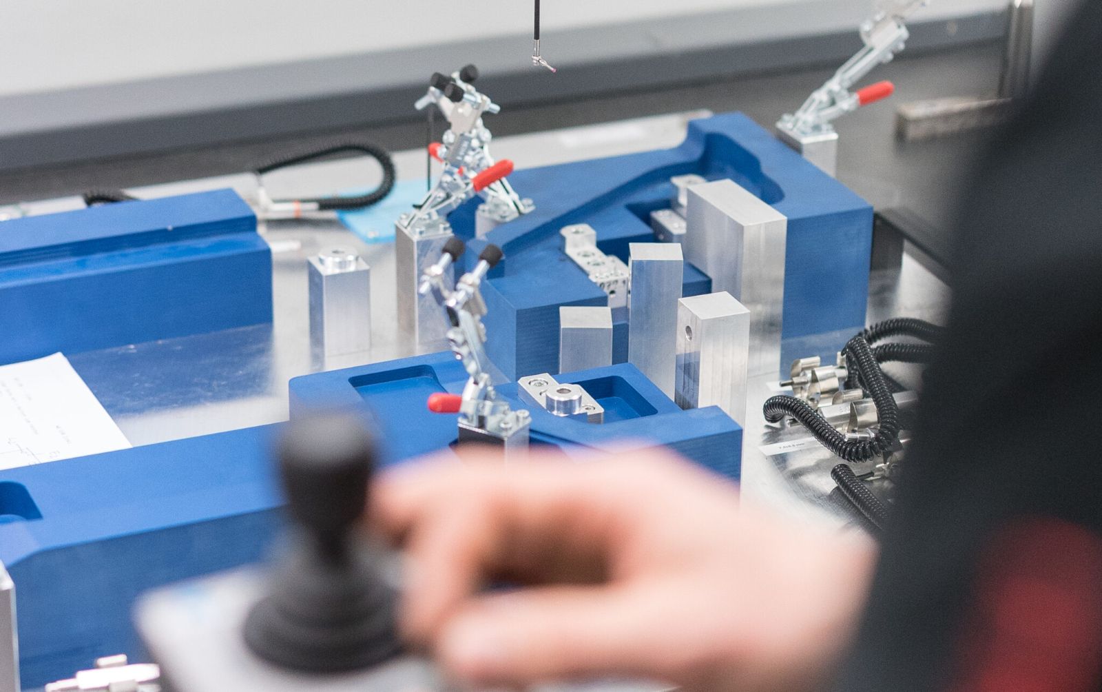 Messtechnik bei metz systems: 3D-Koordinatenmessgerät prüft ein Bauteil in einer Vorrichtung und dokumentiert die Maßhaltigkeit
